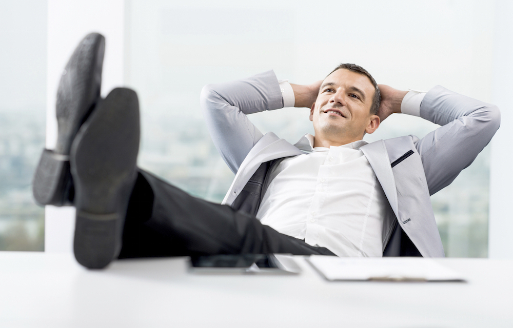 Smiling businessman resting his legs on the desk and enjoying himself.  [url=http://www.istockphoto.com/search/lightbox/9786622][img]http://dl.dropbox.com/u/40117171/business.jpg[/img][/url]